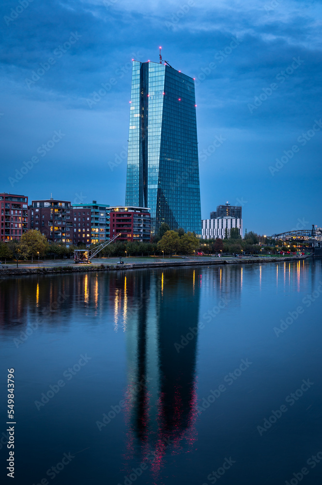 Naklejka premium European central bank with reflections in river Main during blue hour