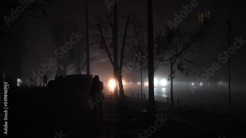 Blackout in the city. No street lightning. Light from cars during fog night.