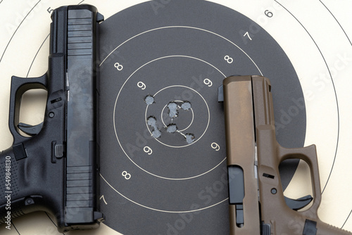 Firearms shooting, pistols and target for shooting with bullet holes in the center.