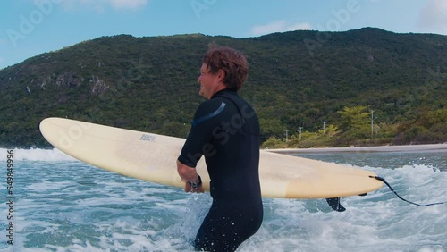 Surfer goes into the ocean through the wave and makes splash