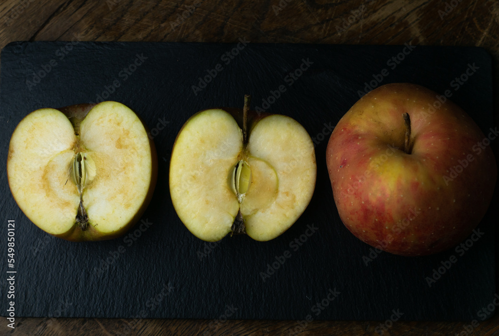 Gold Reinette apple, an old traditional variety of fruits in dark, moody setting on wooden table with delicate light.