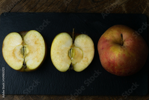 Obraz na płótnie Gold Reinette apple, an old traditional variety of fruits in dark, moody setting on wooden table with delicate light. w salonie