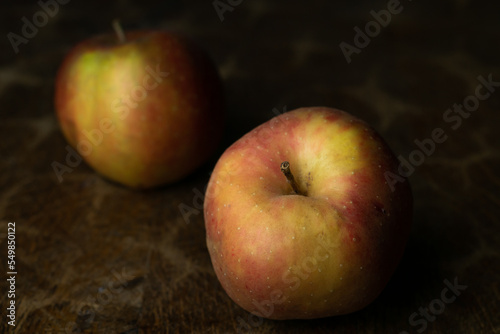 Obraz na płótnie Gold Reinette apple, an old traditional variety of fruits in dark, moody setting on wooden table with delicate light. w salonie