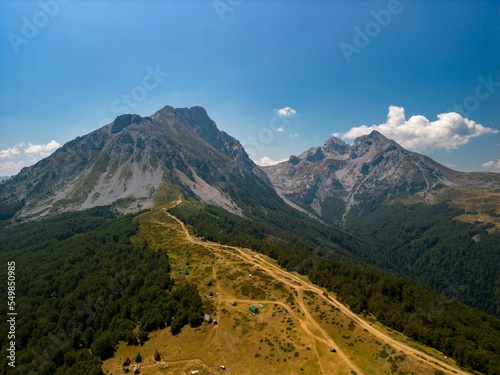 Aerial shot of green-covered mount Komovi under the blue sky in  Montenegro photo