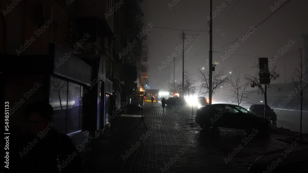 Blackout in the city. No street lightning. Light from cars during fog night.
