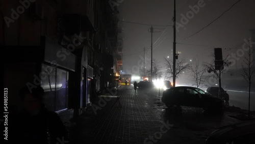 Blackout in the city. No street lightning. Light from cars during fog night.