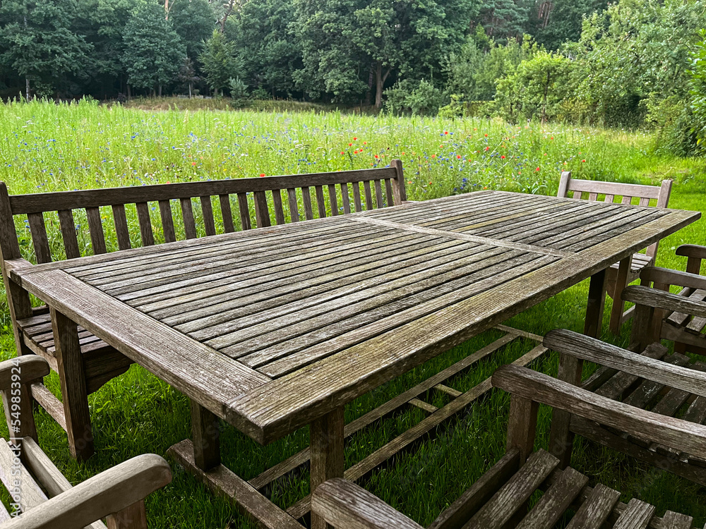 Wooden table with bench and chairs in garden. Landscape design Wooden table with bench and chairs in garden. Landscape design