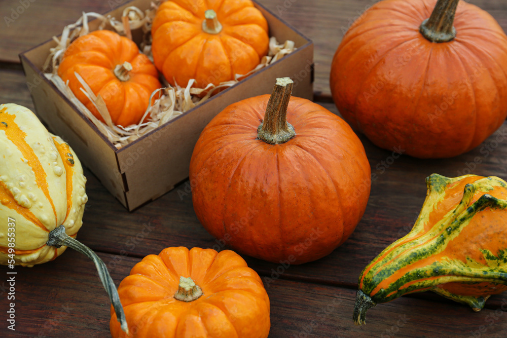 Crate and many different pumpkins on wooden table Crate and many different pumpkins on wooden table