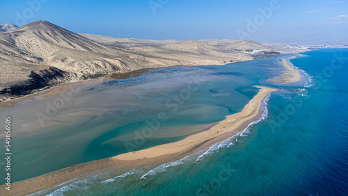 Aerial view of the Sotavento beach in the south of Fuerteventura in the Canary Islands, Spain - Sand strip in the Atlantic Ocean among a desertic barren landscape