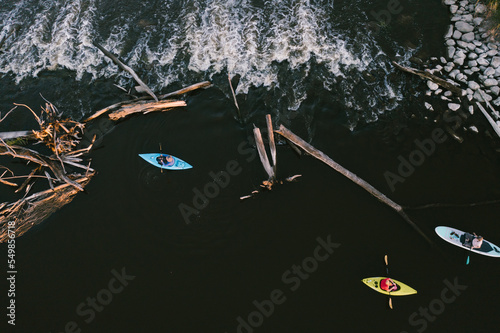 Kayaks from above in river by small waterfall in summer photo