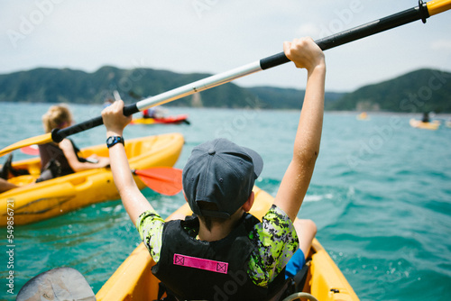 Excited boy in kayak on ocean adventure with family and group photo