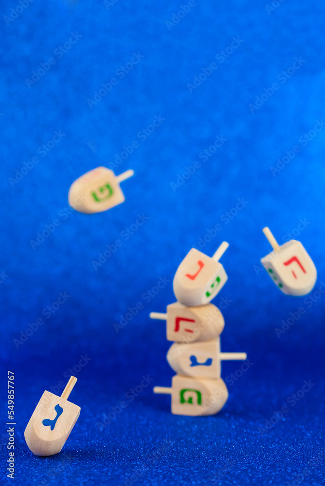 Obraz premium Jewish holiday Hanukkah concept. Wooden dreidel (spinning top) levitation on blue background.