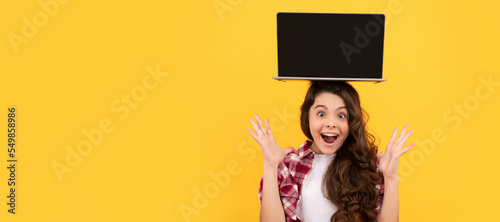 amazed smart kid with laptop on head presenting school online lesson, elearning. School girl portrait with laptop, horizontal poster. Banner header with copy space.