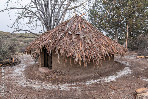 Thatched adobe house during hail
