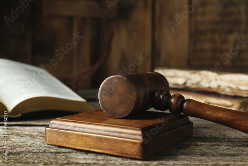 Judge gavel on old wooden table, closeup