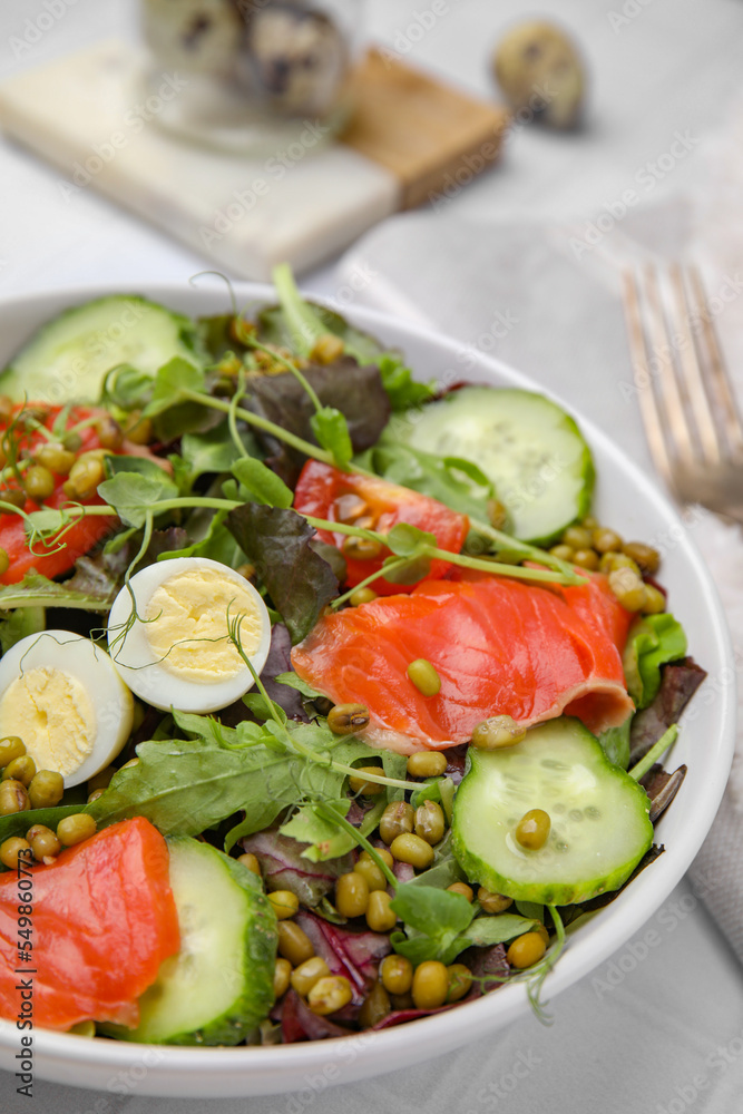 Bowl of salad with mung beans on white tiled table, closeup