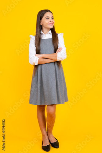 Teenager child girl casual clothes posing isolated on yellow background in studio. Kids lifestyle concept.