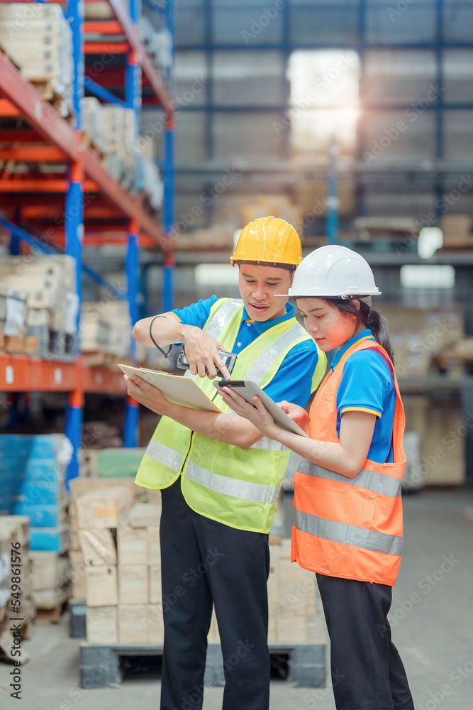Asian engineer in helmets order and checking goods and supplies on shelves with goods background in warehouse.logistic and business export ,Warehouse worker checking packages on shelf in a large store Asian engineer in helmets order and checking goods and supplies on shelves with goods background in warehouse.logistic and business export ,Warehouse worker checking packages on shelf in a large store
