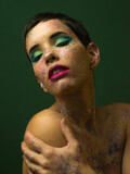 Portrait of young fashion model with strong make up and glitter on her face	