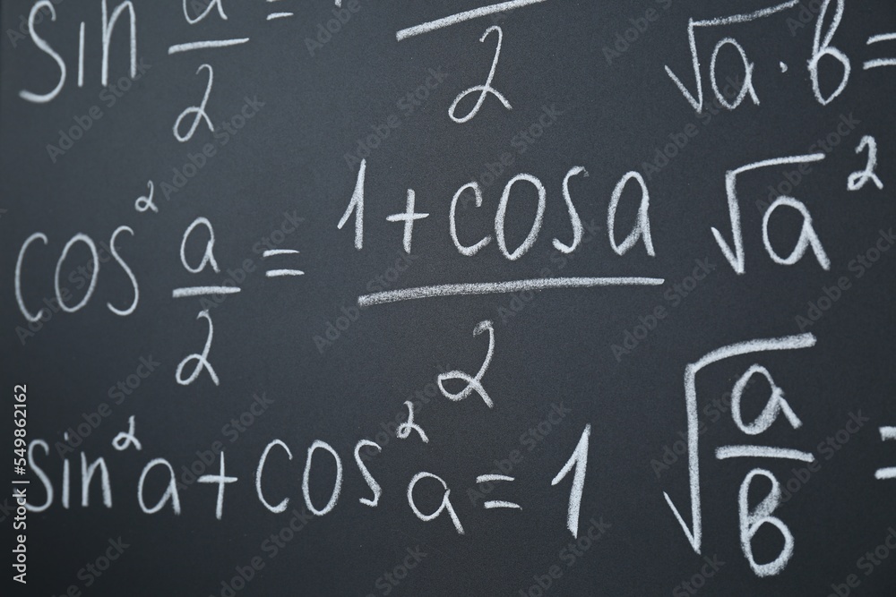 Different mathematical formulas written with chalk on blackboard, closeup Different mathematical formulas written with chalk on blackboard, closeup