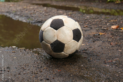 Dirty soccer ball near puddle on ground © New Africa