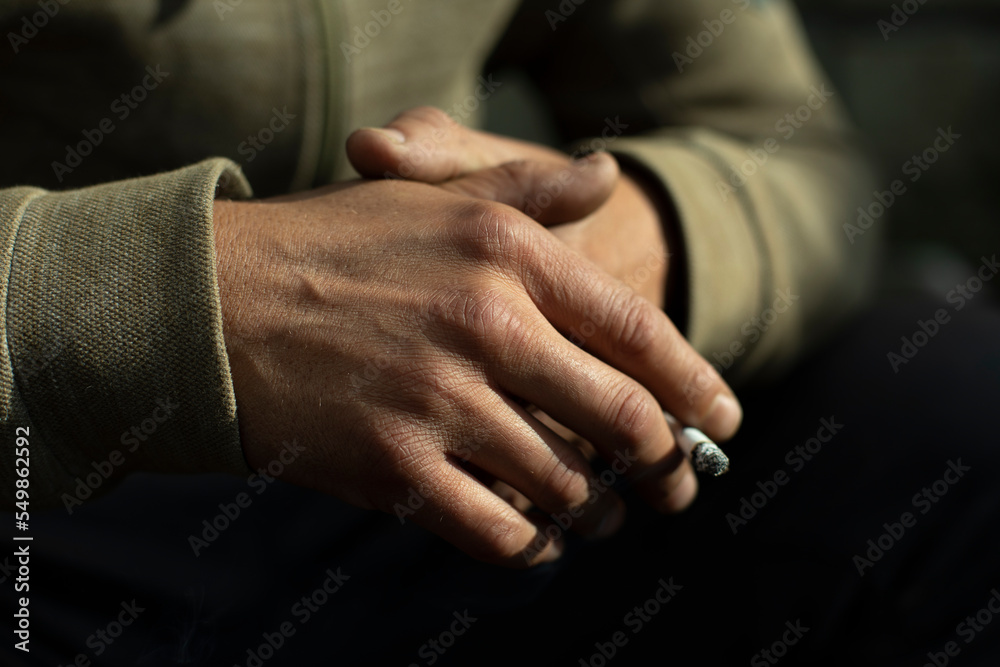 Hand in detail. Cigarette sandwiched between packs.