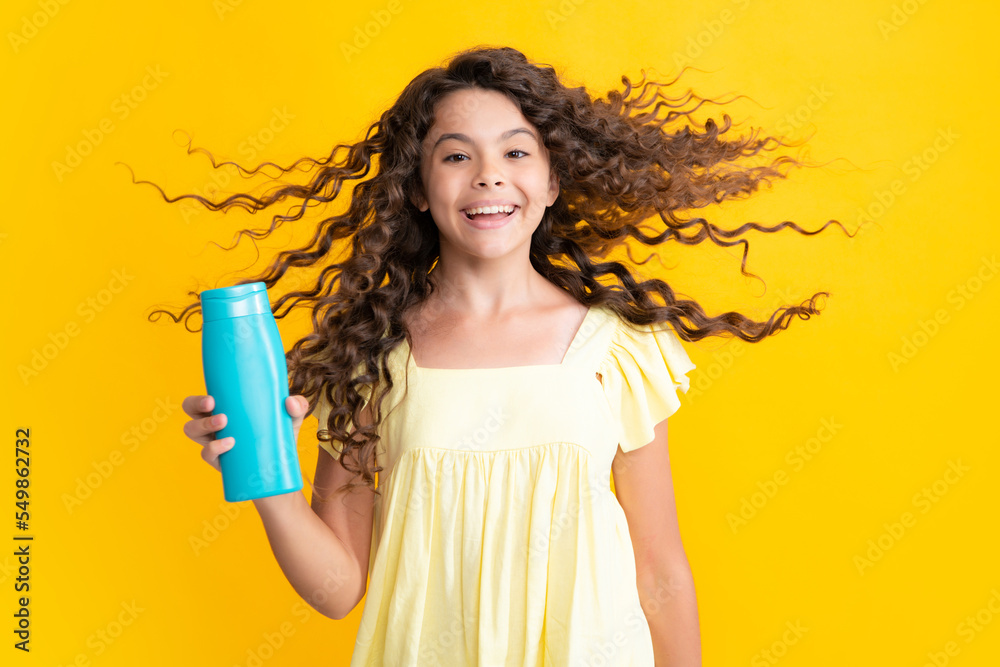 Teenager child girl showing bottle shampoo conditioners or shower gel isolated on yellow background. Hair cosmetic product. Mock up bottle. Excited teenager, glad amazed and overjoyed emotions. Teenager child girl showing bottle shampoo conditioners or shower gel isolated on yellow background. Hair cosmetic product. Mock up bottle. Excited teenager, glad amazed and overjoyed emotions.
