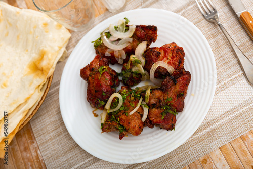 Traditional oriental grilled pork meat shashlik served with onion and lavash