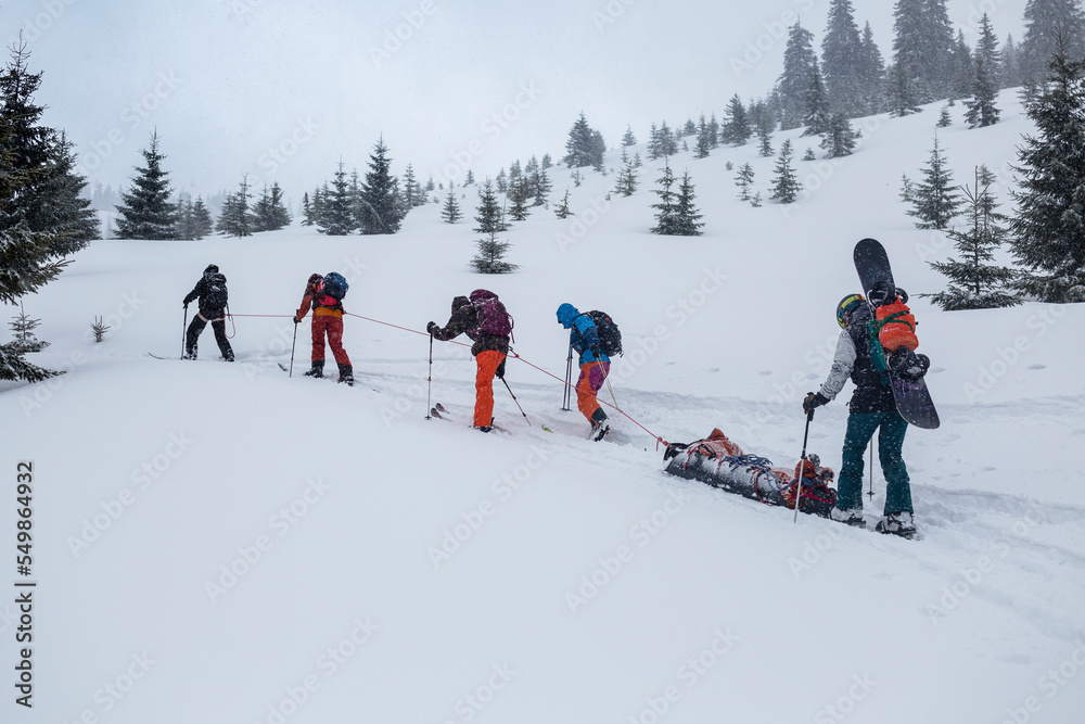 Ski rescuers pull a special sled (akya) in the mountains with the victim in the middle