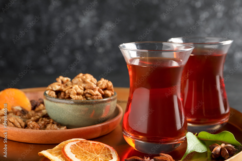 Tray with glasses of traditional Turkish tea, walnuts, dried orange and anise on table, closeup Tray with glasses of traditional Turkish tea, walnuts, dried orange and anise on table, closeup