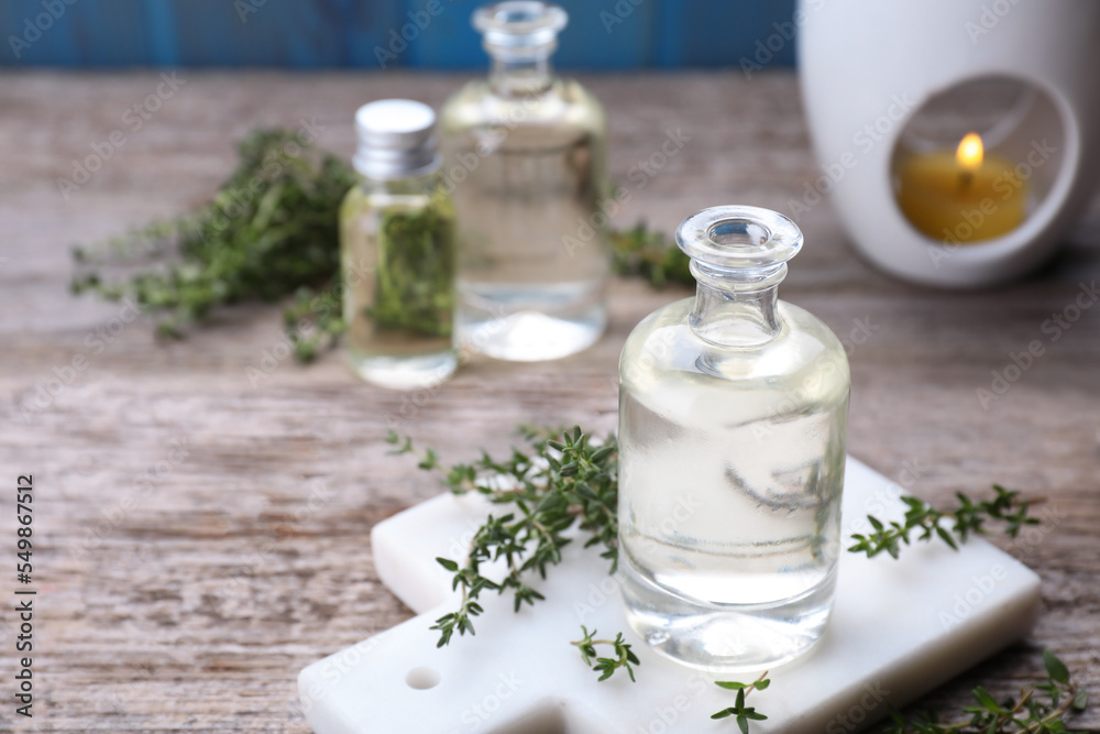 Thyme essential oil and fresh plant on wooden table, space for text Thyme essential oil and fresh plant on wooden table, space for text