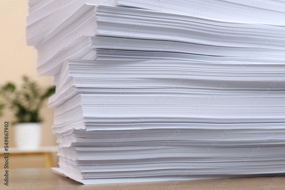 Stack of paper sheets on wooden table indoors, closeup Stack of paper sheets on wooden table indoors, closeup