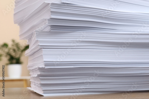 Stack of paper sheets on wooden table indoors, closeup