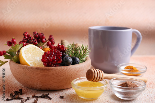 Cup of delicious immunity boosting tea and ingredients on color textured background