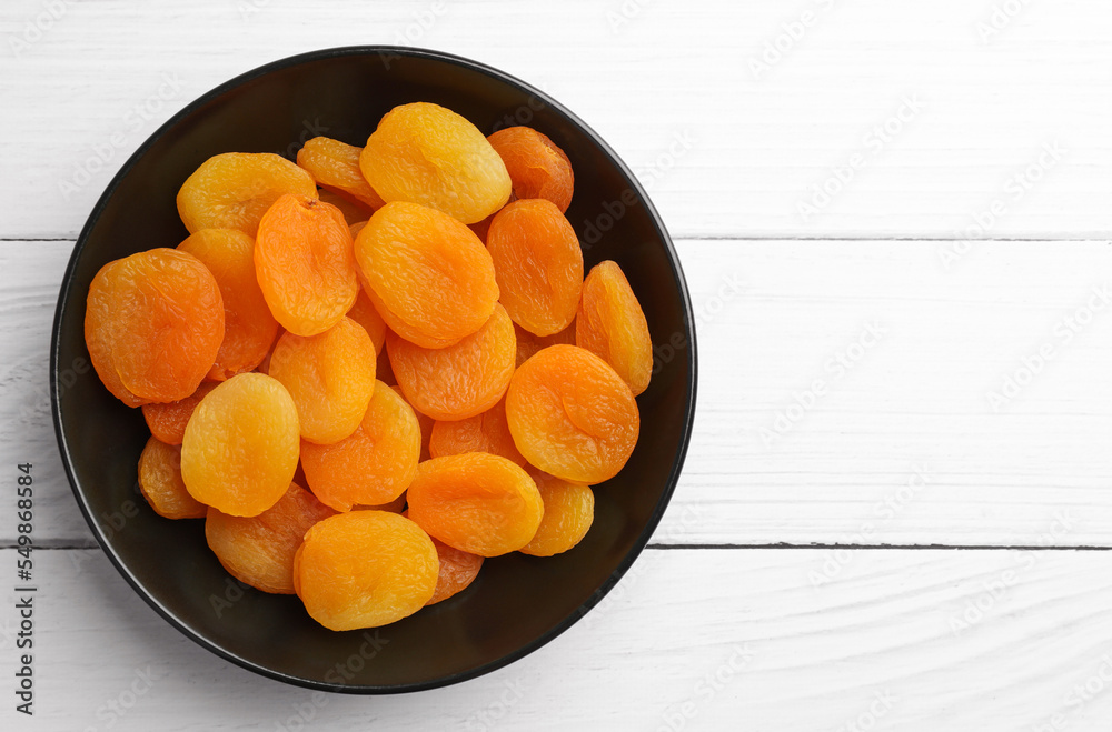 Plate of tasty apricots and space for text on white wooden table, top view. Dried fruits Plate of tasty apricots and space for text on white wooden table, top view. Dried fruits