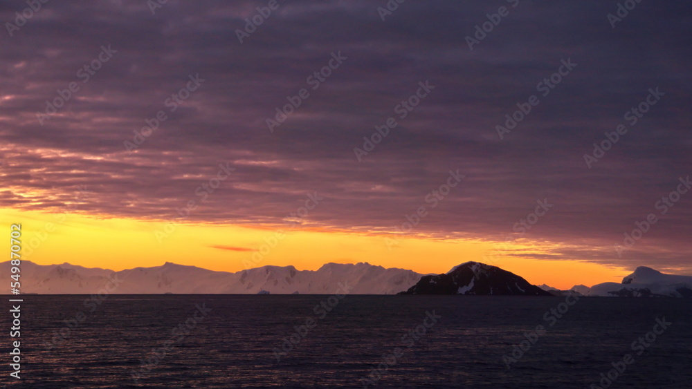 Sunset over the silhouette of mountains at Cierva Cove, Antarctica Sunset over the silhouette of mountains at Cierva Cove, Antarctica