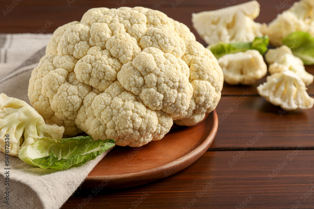 Plate with fresh raw cauliflower on wooden table Plate with fresh raw cauliflower on wooden table