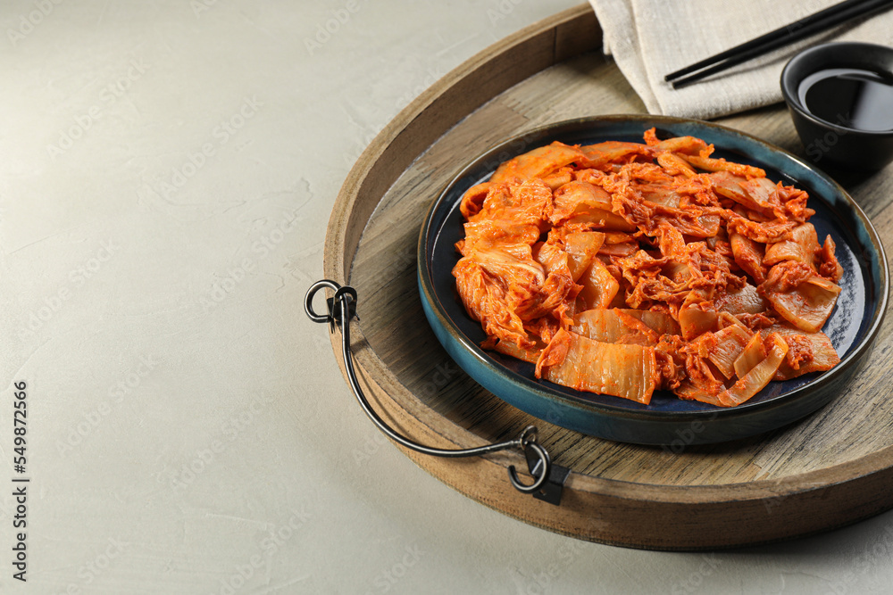 Delicious kimchi with Chinese cabbage and sauce on light grey table, space for text Delicious kimchi with Chinese cabbage and sauce on light grey table, space for text