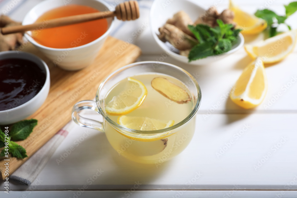 Delicious ginger tea and ingredients on white wooden table Delicious ginger tea and ingredients on white wooden table
