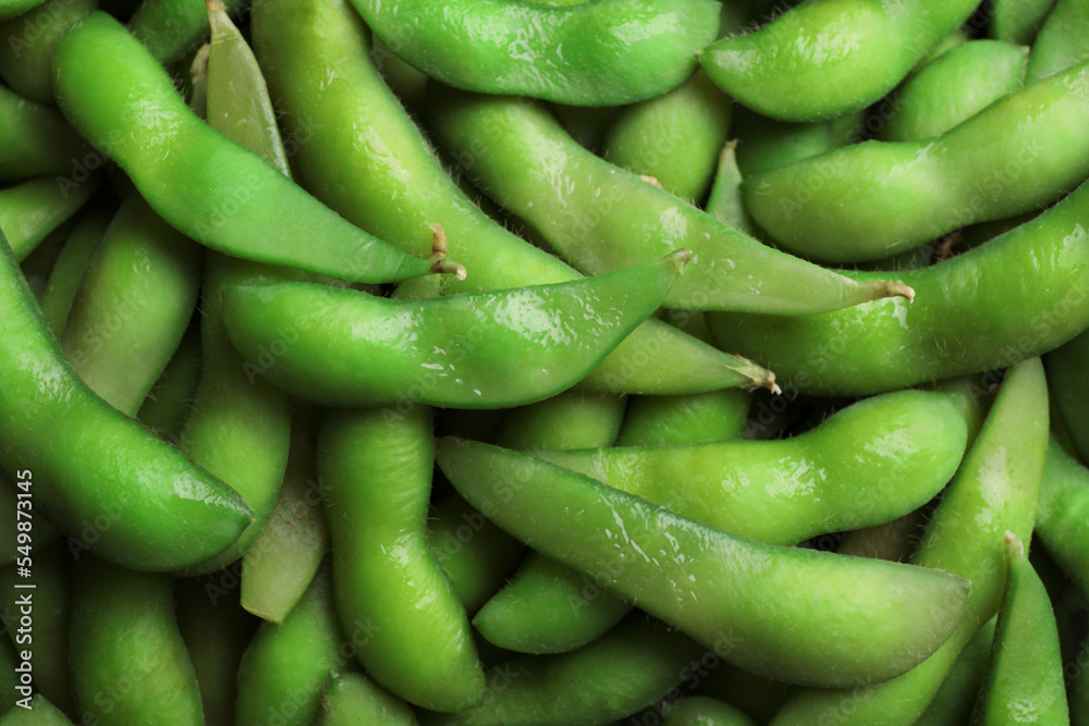 Many green edamame beans in pods as background, closeup