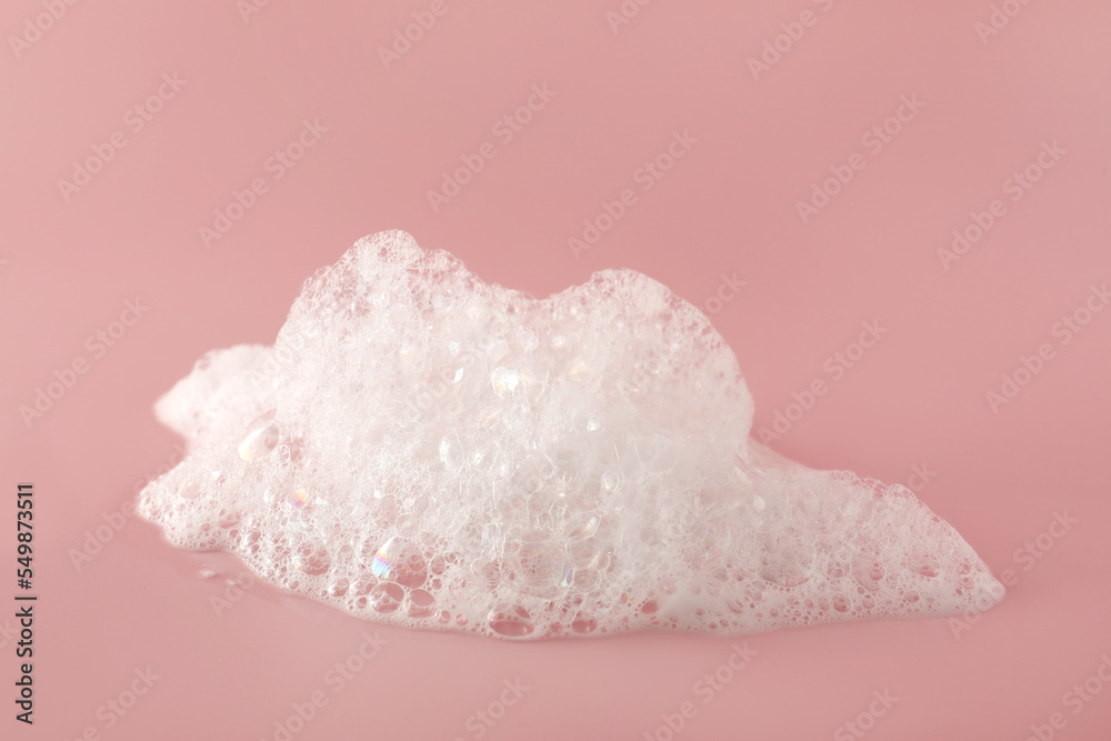Fluffy bath foam on pink background, closeup. Care product Stock Photo