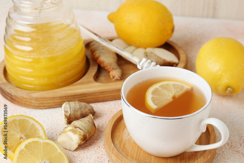 Tea, honey, lemon and ginger on beige textured table Tea, honey, lemon and ginger on beige textured table