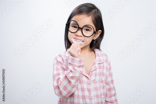 little girl Asia brushing teeth happily white background