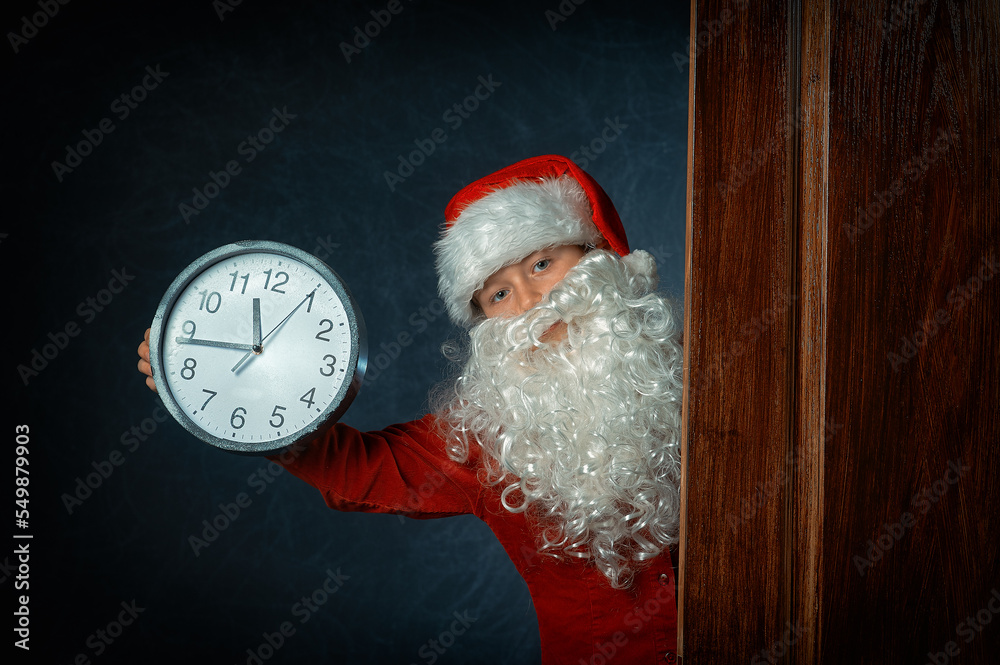 portrait of a boy in a santa costume with a clock