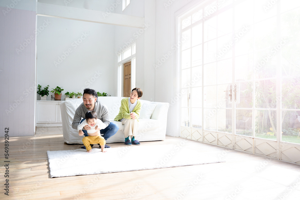 リビングでかわいい子どもと遊ぶ夫婦のイメージ リビングでかわいい子どもと遊ぶ夫婦のイメージ