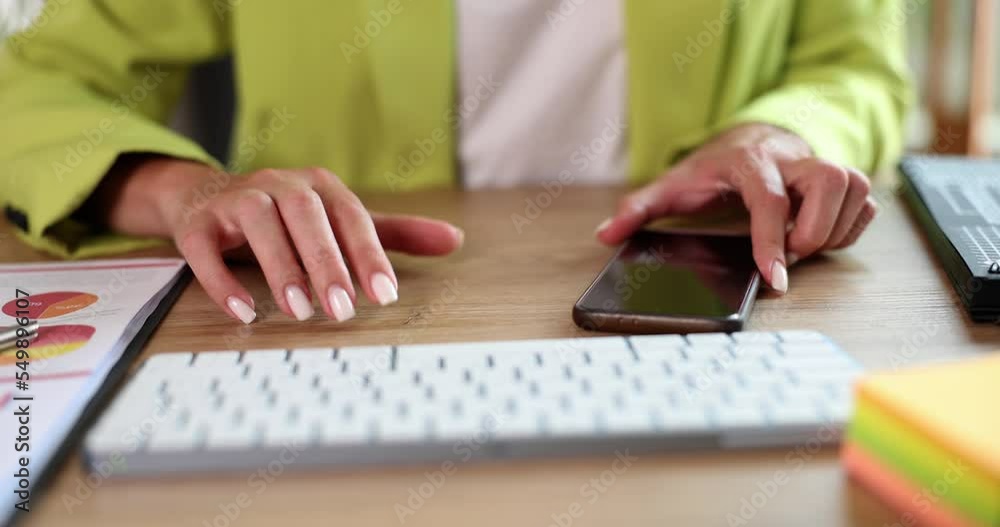 Woman tapping fingers sits at table and waits for call