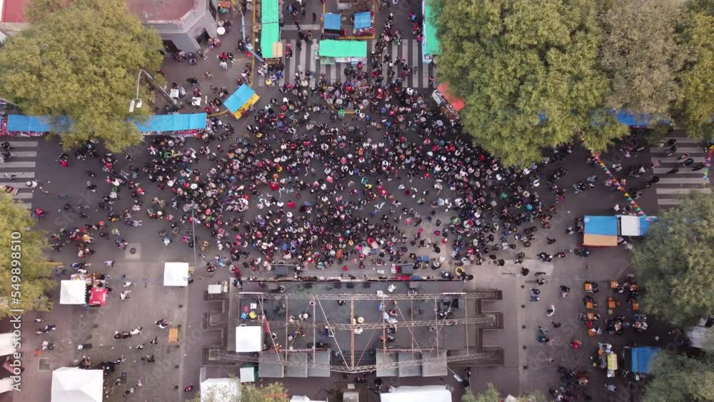 People dancing Chacarera folk popular dance during Feria de Mataderos in Buenos Aires city, Argentina. Aerial top-down ascending directly above