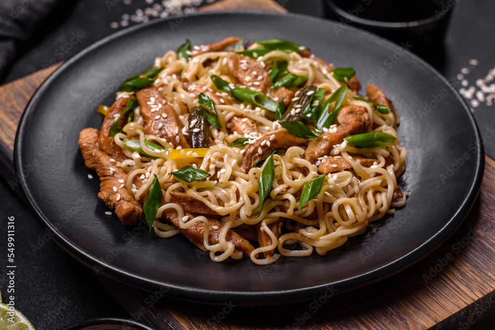Tasty dish of Asian cuisine with rice noodles, chicken, asparagus, pepper, sesame seeds and soy sauce Tasty dish of Asian cuisine with rice noodles, chicken, asparagus, pepper, sesame seeds and soy sauce