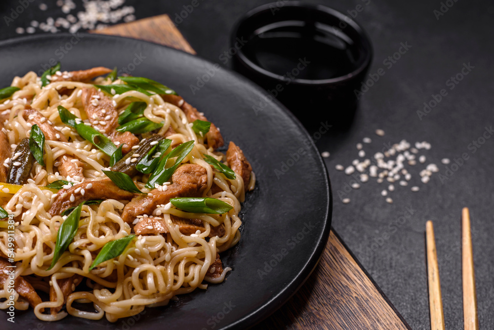 Tasty dish of Asian cuisine with rice noodles, chicken, asparagus, pepper, sesame seeds and soy sauce Tasty dish of Asian cuisine with rice noodles, chicken, asparagus, pepper, sesame seeds and soy sauce