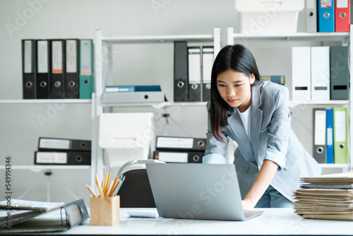 Young asian businesswoman working at office using laptop.